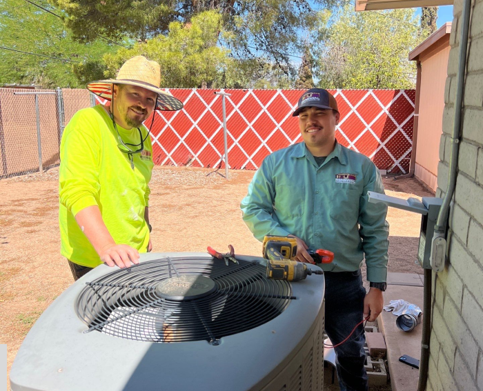 Two men reviewing AC unit